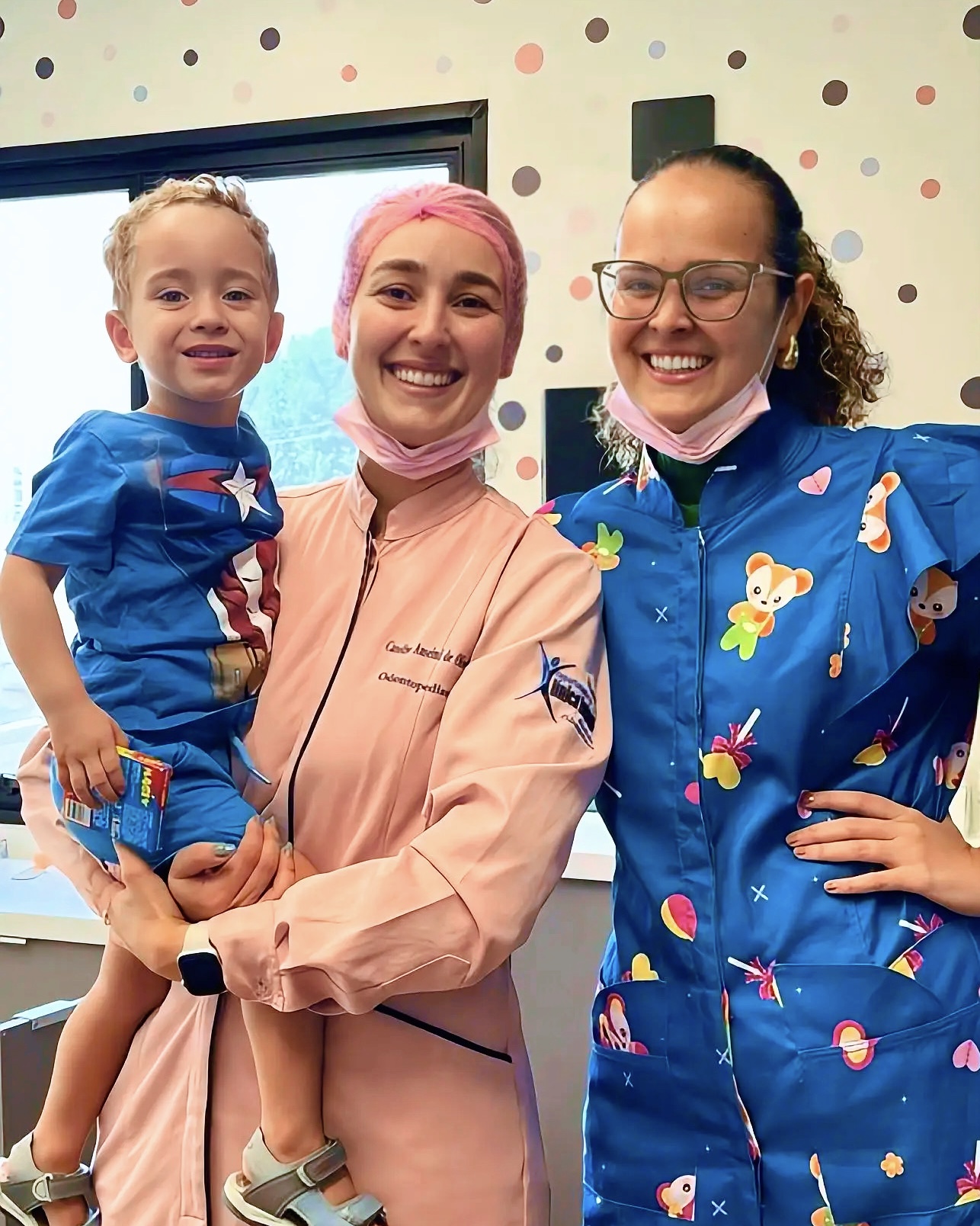 Equipe Oraliv Kids com criança após atendimento de odontopediatria